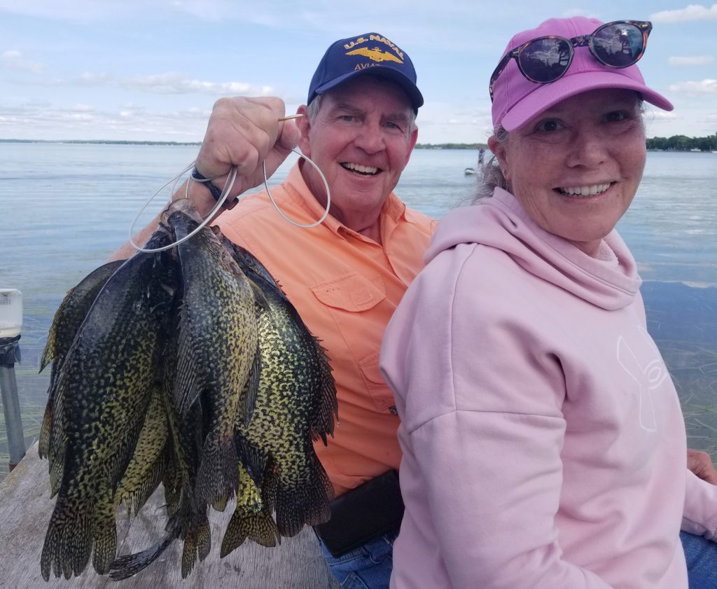 A man and woman hold up a string of fish caught on a Minnesota lake